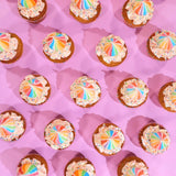 Unicorn Cupcakes from Crumbs & Doilies with rainbow Swiss meringue buttercream and sprinkles on pink background